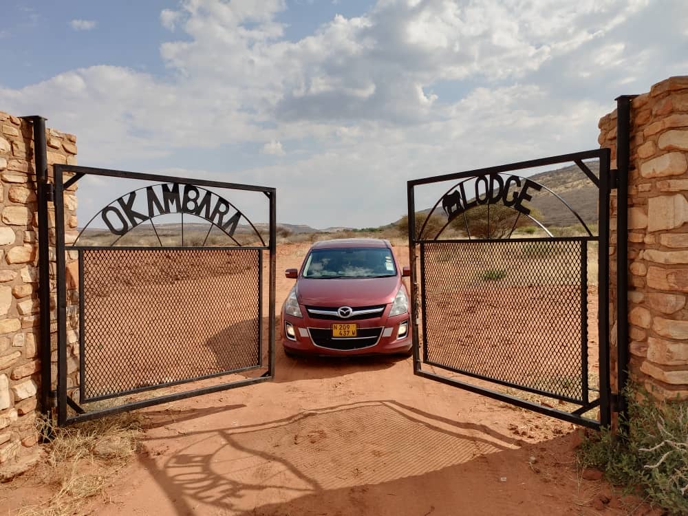 M·L Transfer van framed by the gates of Okambara Lodge