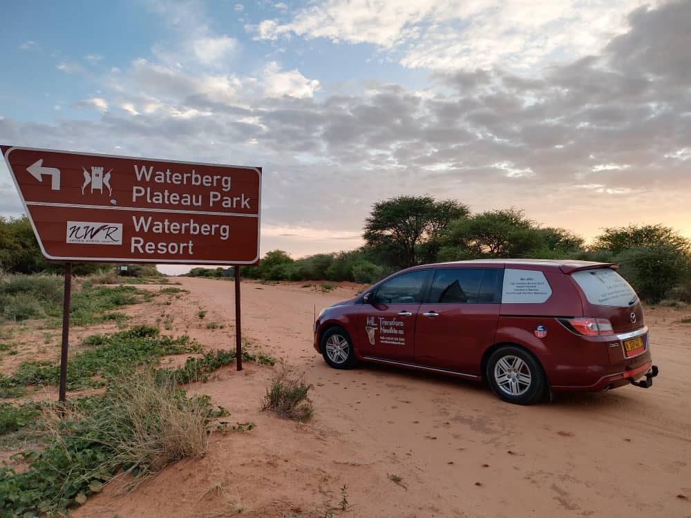 M·L Transfer van at the Waterberg Plateau Park sign at sunset